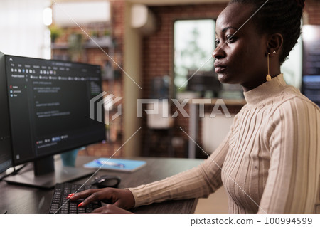 African american programmer typing big data code on computer, sitting at desk developing program using html script. Tech enginner writing ai algorithm working in it programming agency African american programmer typing big data code on computer, sitting at desk developing program using html script. Tech enginner writing ai algorithm working in it programming agency 100994599