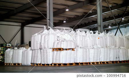 large, full bags of cereal products in stock. The bags are stacked in rows, industrial warehouse large, full bags of cereal products in stock. The bags are stacked in rows, industrial warehouse 100994716