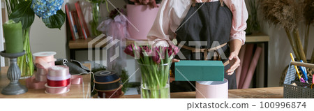 Professional florist young woman is doing bouquets at flower shop Professional florist young woman is doing bouquets at flower shop 100996874