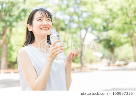 A woman who rehydrates with water / oral rehydration solution A woman who rehydrates with water / oral rehydration solution 100997356