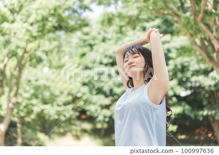 A woman stretching in fresh green 100997636