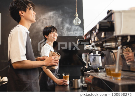 Men and women working at a cafe Men and women working at a cafe 100998275