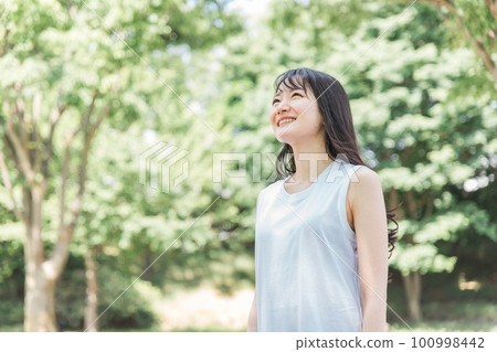 Japanese woman taking a deep breath in the green (relax and refresh) Japanese woman taking a deep breath in the green (relax and refresh) 100998442