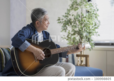 Man in his 60s playing the guitar 100998605