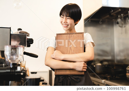 一個女人在一家咖啡館工作 100998761