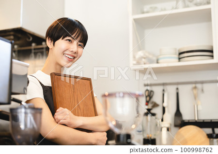 一個女人在一家咖啡館工作 100998762