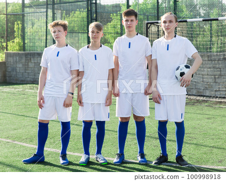 Young football team standing on pitch 100998918