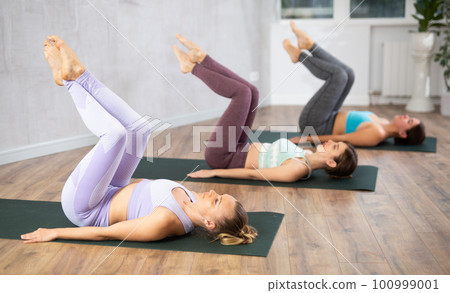 Three women doing yoga in fitness studio Three women doing yoga in fitness studio 100999001