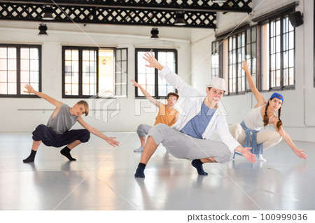 Team of young dancers training moves 100999036
