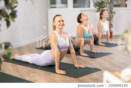 Three women doing yoga in fitness studio Three women doing yoga in fitness studio 100999195