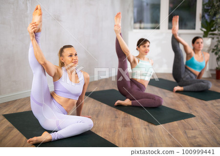 Three women doing yoga in fitness studio Three women doing yoga in fitness studio 100999441