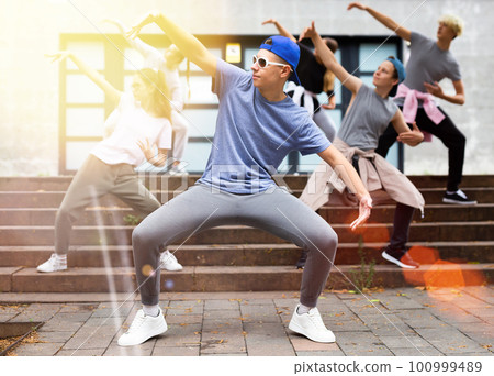 Teenagers boy and girls performing hip hop at street Teenagers boy and girls performing hip hop at street 100999489