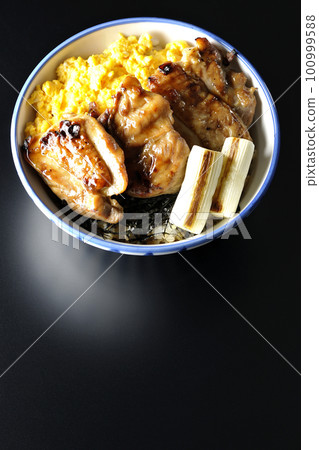 Teriyaki chicken bowl topped with soboro egg, grilled green onion and chopped seaweed on a black background Teriyaki chicken bowl topped with soboro egg, grilled green onion and chopped seaweed on a black background 100999588