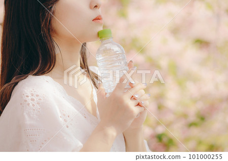 櫻花樹下拿著塑料瓶的女人 101000255