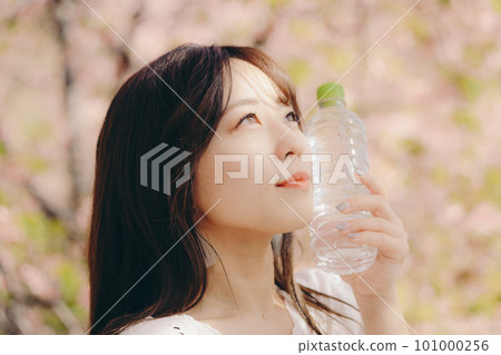 櫻花樹下拿著塑料瓶的女人 101000256