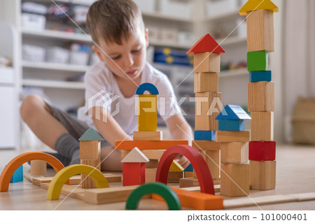 Confident male kid building fortress tower architecture wooden bricks ecology Montessori material 101000401