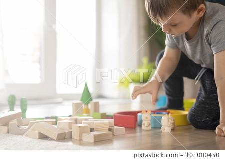 Confident male kid building fortress tower architecture wooden bricks ecology Montessori material 101000450