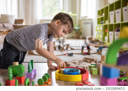 Confident male kid building fortress tower architecture wooden bricks ecology Montessori material 101000451