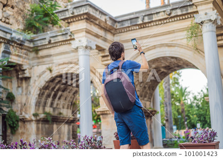 Happy male tourist traveler discover interesting places and popular attractions and walks in the old city of Antalya. Hadrian Kapisi turkey landmark city history. Popular tourist attraction - ancient Happy male tourist traveler discover interesting places and popular attractions and walks in the old city of Antalya. Hadrian Kapisi turkey landmark city history. Popular tourist attraction - ancient 101001423