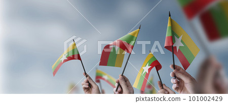 A group of people holding small flags of the Myanmar in their hands A group of people holding small flags of the Myanmar in their hands 101002429