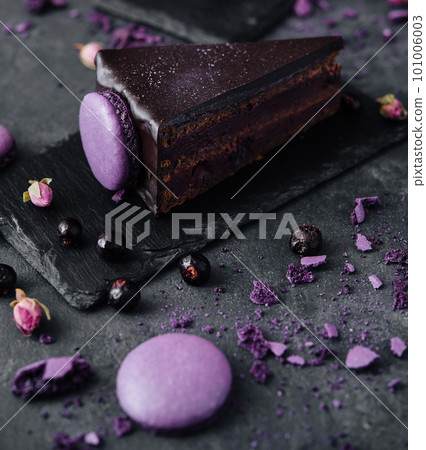 chocolate cake with macaroons on black board 101006003
