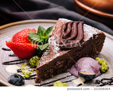 Brownie cake with a scoop of vanilla ice cream and strawberries Brownie cake with a scoop of vanilla ice cream and strawberries 101006064