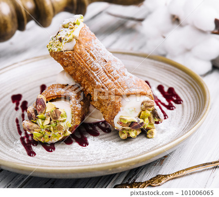 Traditional italian dessert cannoli siciliani on plate 101006065