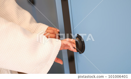 Women hands in bathrobe opening doors of blue wardrobe at home closeup 101006401