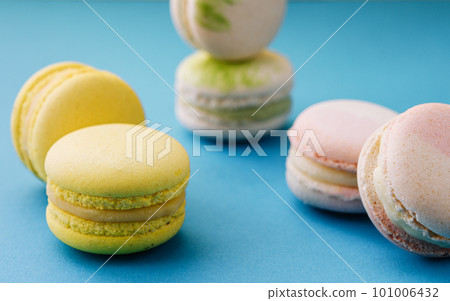 Sweet and colorful macaroons on blue with yellow background 101006432