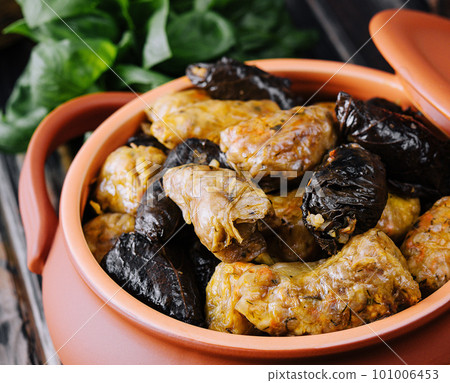 Dolma with meat, rice in grape leaves in a clay pot Dolma with meat, rice in grape leaves in a clay pot 101006453