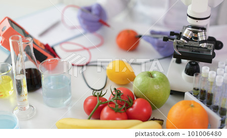 Scientist chemist studying amount of toxic substances in vegetables and fruits in chemical laboratory Scientist chemist studying amount of toxic substances in vegetables and fruits in chemical laboratory 101006480