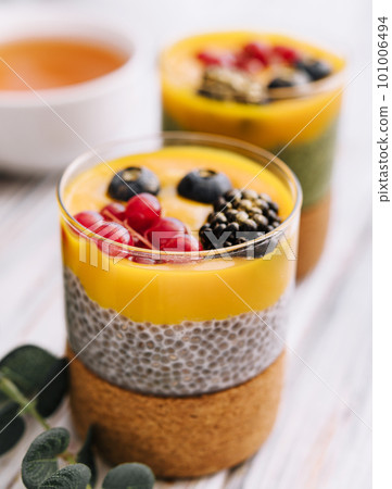 Healthy vegan chia pudding with mango sauce and fresh berries Healthy vegan chia pudding with mango sauce and fresh berries 101006494