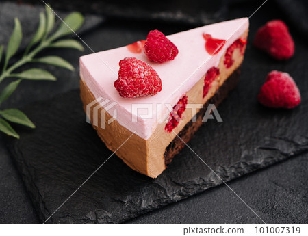 Pieces of cheesecake with raspberries on black board Pieces of cheesecake with raspberries on black board 101007319