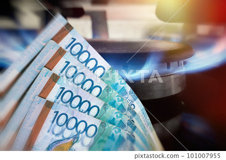 Kazakh money Tenge on the background of a kitchen gas burner. The concept of expensive natural gas Kazakh money Tenge on the background of a kitchen gas burner. The concept of expensive natural gas 101007955