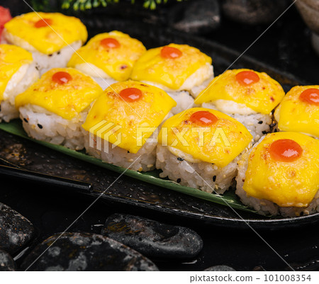 sushi with cheddar cheese on black plate top with yellow curry 101008354