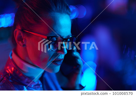 trendy woman in glasses using smartphone in modern office 101008570
