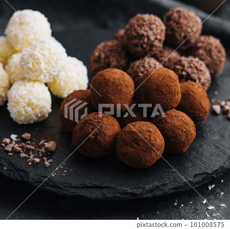 three types of chocolate balls on stone board 101008575