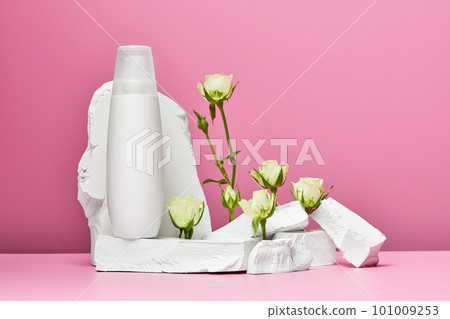 bottle of cream or body lotion with stones and white roses 101009253