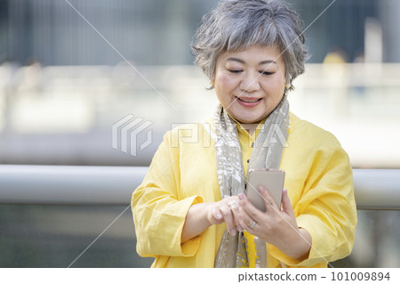 Senior woman operating a smartphone Senior woman operating a smartphone 101009894