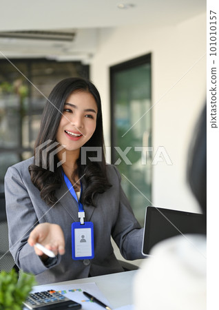 Charming Asian female banker explaining a new financial investment campaign to a customer. 101010157