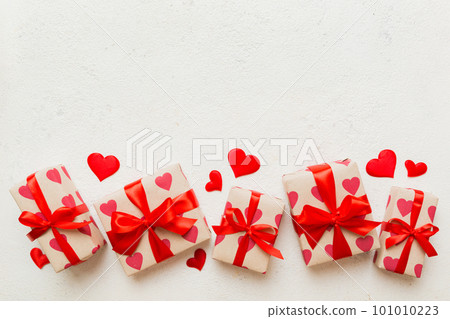 Top view photo of valentine day decorations gift box with red ribbon bow on colored background. Holiday gift boxes with top view 101010223