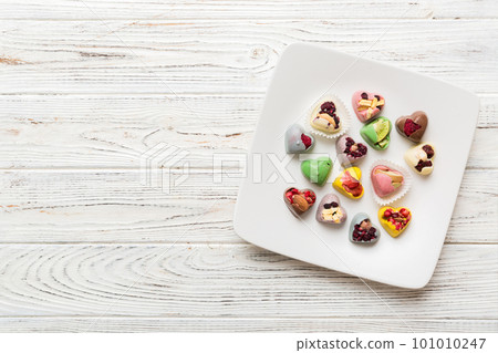 Plate with different chocolate on colored background. Assortment of fine chocolates top view vith copy space Health and obesity concept Plate with different chocolate on colored background. Assortment of fine chocolates top view vith copy space Health and obesity concept 101010247