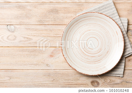Top view on colored background empty round white plate on tablecloth for food. Empty dish on napkin with space for your design Top view on colored background empty round white plate on tablecloth for food. Empty dish on napkin with space for your design 101010248