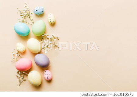 Happy Easter composition. Easter eggs on colored table with gypsophila. Natural dyed colorful eggs background top view with copy space 101010573