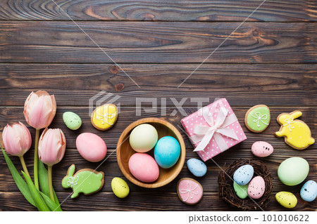 Easter frame with eggs, gift box and tulip on a colored background. The minimal concept. Top view Happy Easter composition. Card with a copy space of the place for the text Easter frame with eggs, gift box and tulip on a colored background. The minimal concept. Top view Happy Easter composition. Card with a copy space of the place for the text 101010622