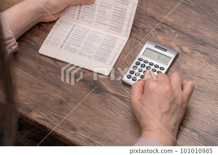 [Housewife calculating while looking at the bankbook] 101010985