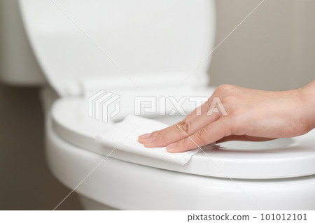 woman using tissue paper clean the toilet in the bathroom at home. woman using tissue paper clean the toilet in the bathroom at home. 101012101