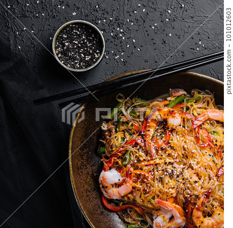 Stir fry noodles with vegetables and shrimps in black bowl Stir fry noodles with vegetables and shrimps in black bowl 101012603
