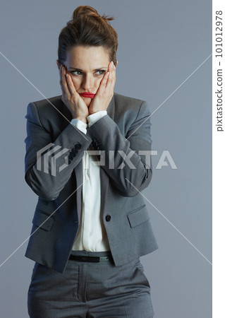 stressed trendy business woman in gray suit isolated on grey stressed trendy business woman in gray suit isolated on grey 101012978