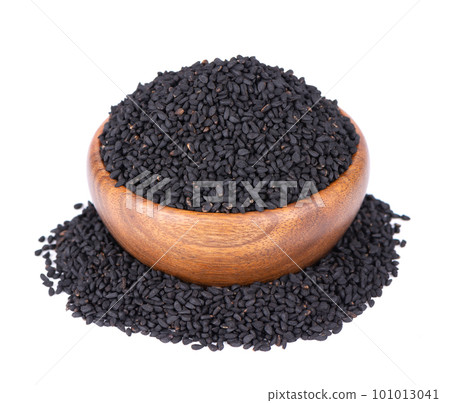 Black cumin seeds in wooden bowl, isolated on white background. Heap of black nigella seeds. Nigella sativa. 101013041